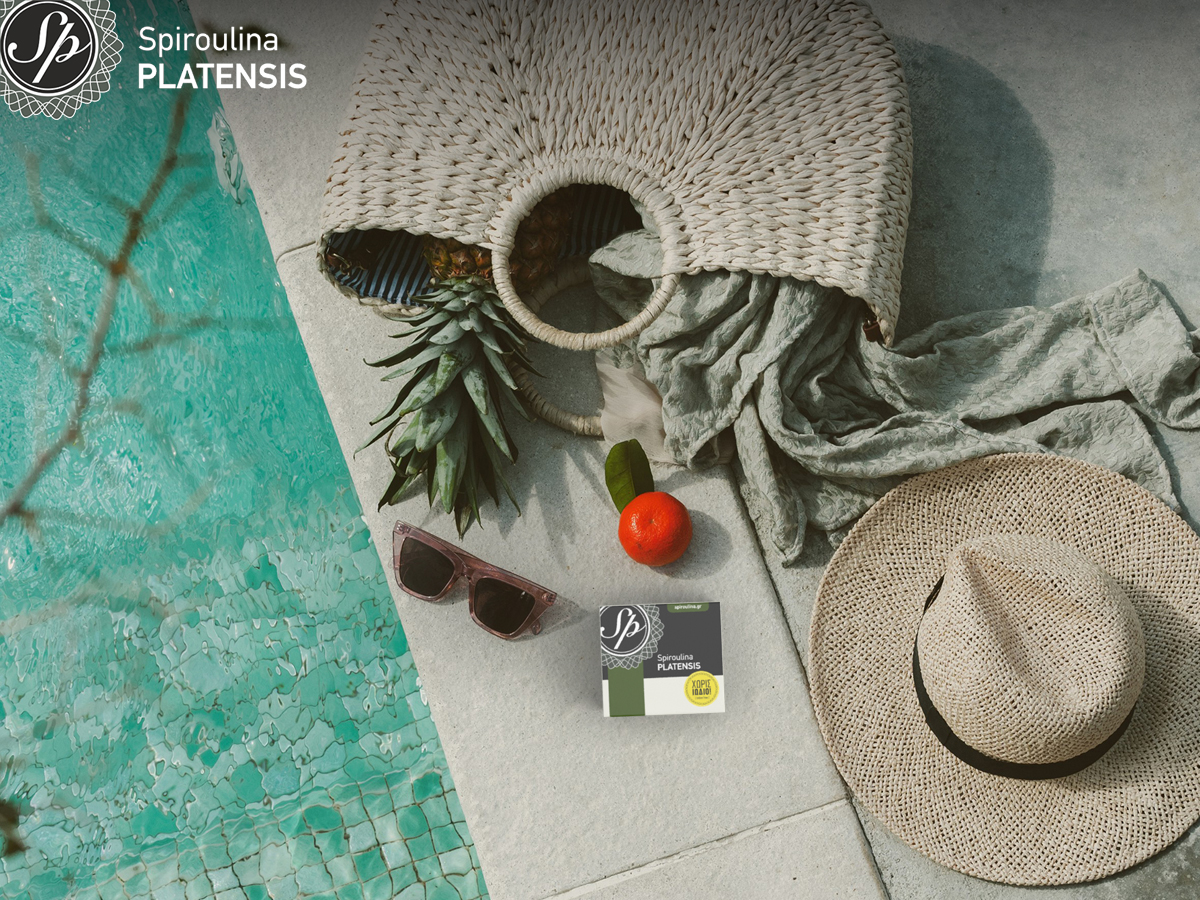 μία συσκευασία spiroulina PLATENSIS σε σκόνη δίπλα σε μία πισίνα και δίπλα ένα ψάθινο καπέλα και μία τσάντα παραλίας
